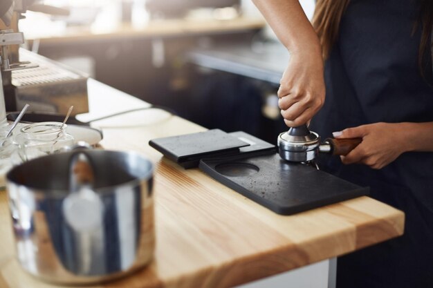 Primo piano del barista che pressa il caffè per preparare il caffè più incredibile che tu abbia mai assaggiato