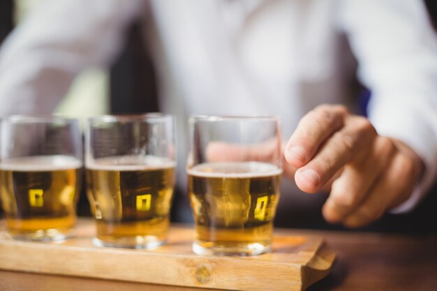 Primo piano del barista che tiene bicchiere di whisky al bancone del bar