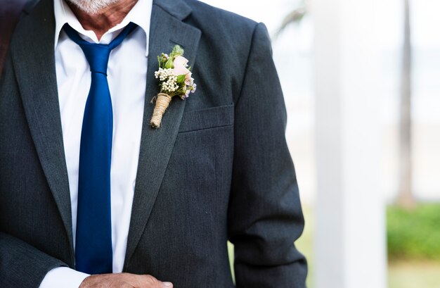 Primo piano del boutonnière dello sposo sul risvolto del vestito