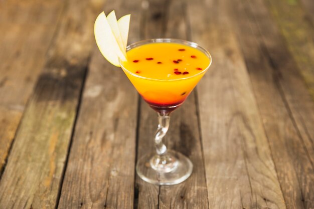 Primo piano del cocktail nel bicchiere da martini sulla scrivania in legno