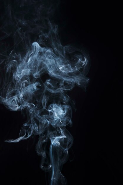 Primo piano del disegno viola del fumo del vapore su fondo nero