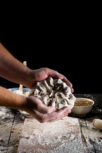 Primo piano del fornaio che impasta la pasta sul tavolo