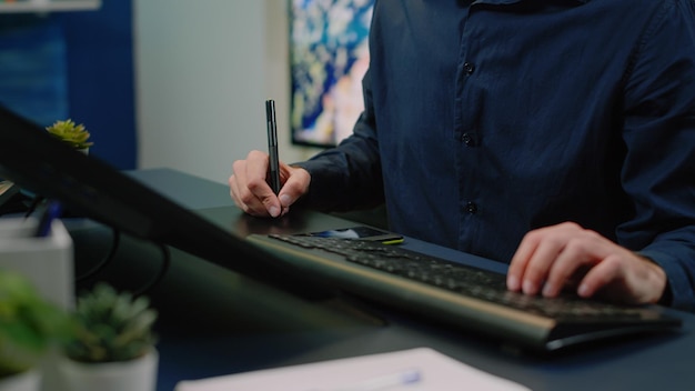 Primo piano del fotografo che utilizza tavoletta grafica e stilo che modificano le immagini in studio fotografico. Editor di immagini che lavora con attrezzature moderne e foto di ritocco di gadget per la produzione multimediale.