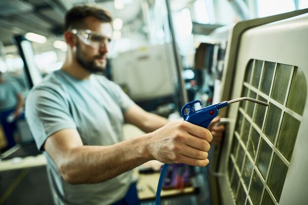 Primo piano del lavoratore manuale presso la struttura della linea di produzione industriale