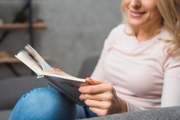 Primo piano del libro di lettura sorridente della giovane donna