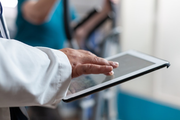 Primo piano del medico che utilizza tablet digitale con touch screen