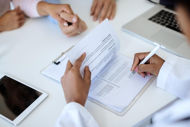 Primo piano del medico femminile che firma i referti medici