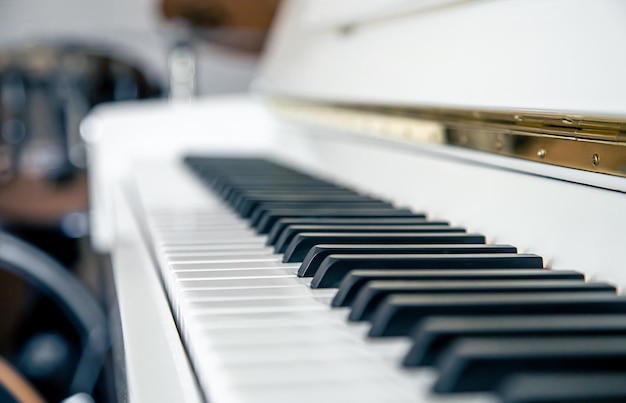 Primo piano del sottofondo musicale bianco dei tasti del pianoforte