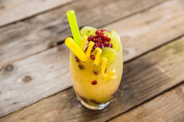 Primo piano del succo di frutta sulla plancia di legno