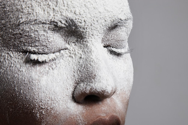 Primo piano del volto di donna coperto da polvere bianca
