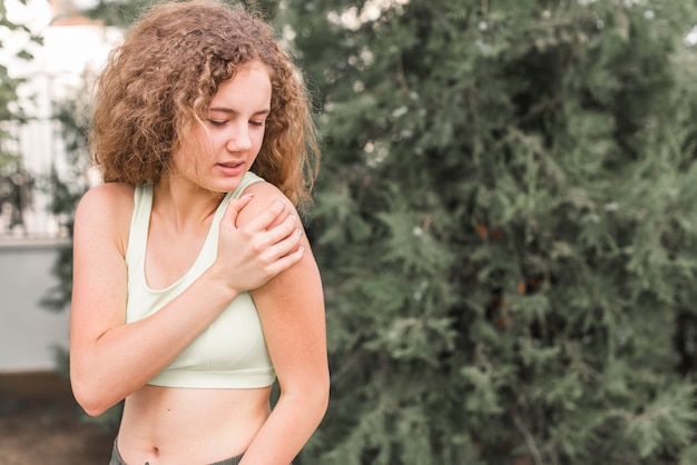 Primo piano dell&#39;atleta femminile che ha dolore in spalla