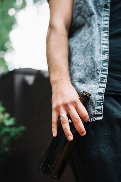 Primo piano dell&#39;uomo che tiene la bottiglia di birra in mano