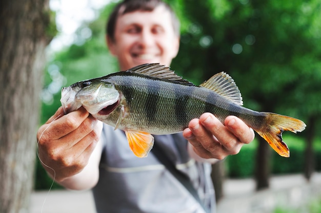 Primo piano dell&#39;uomo che tiene pesce pescato fresco