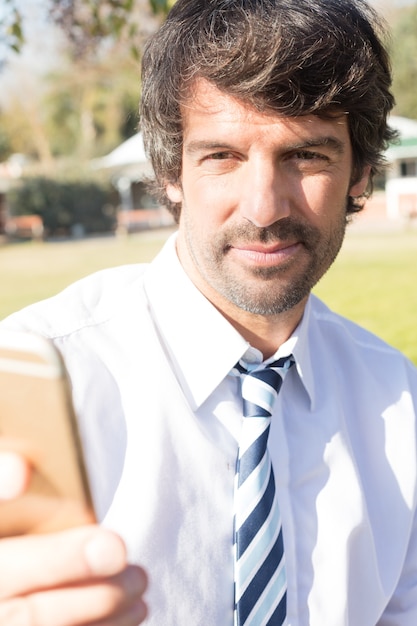 Primo piano dell&#39;uomo d&#39;affari sorridente prendere selfie