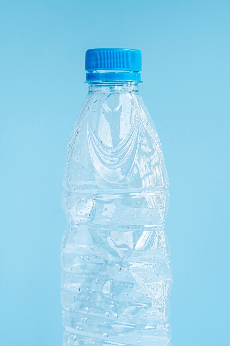 Foto gratuito primo piano della bottiglia di plastica su fondo blu