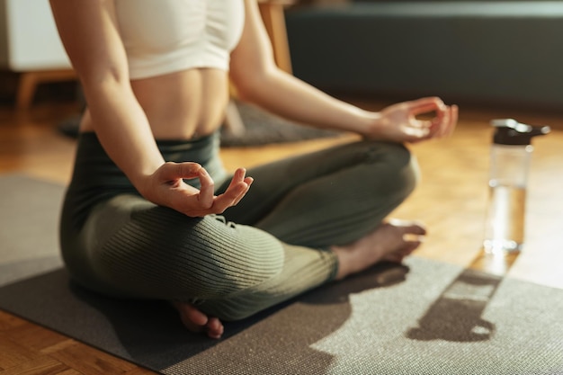 Primo piano della donna atletica che pratica Yoga nella posizione del loto