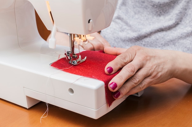 Primo piano della donna che lavora sulla macchina da cucire