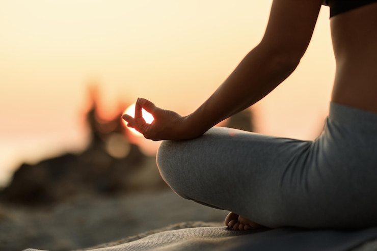 Foto gratuito primo piano della donna che medita nella posizione del loto al tramonto.