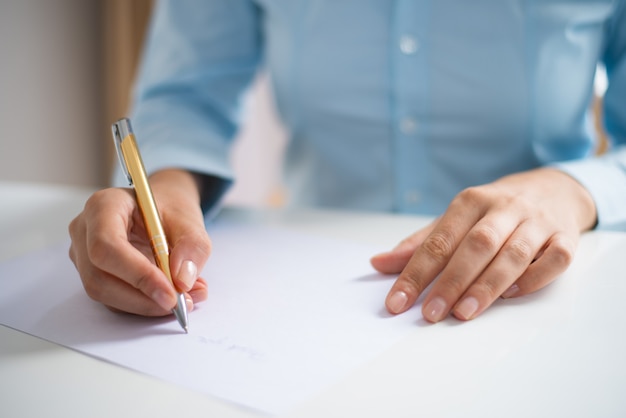 Primo piano della donna che scrive sul foglio di carta