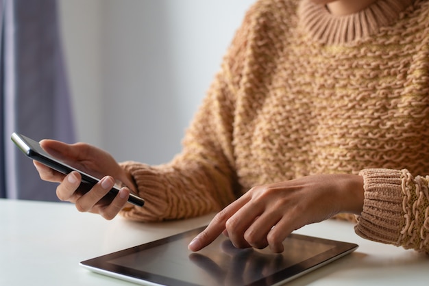 Primo piano della donna di affari che per mezzo dei dispositivi moderni