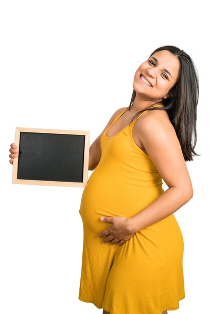 Primo piano della donna incinta che tiene e che mostra qualcosa sulla lavagna