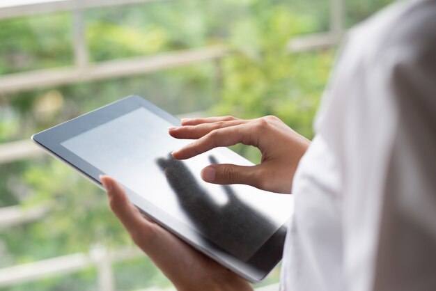 Primo piano della donna irriconoscibile che utilizza compressa digitale.