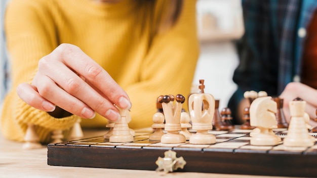 Primo piano della giovane donna che gioca il gioco di scacchiera