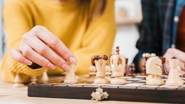 Primo piano della giovane donna che gioca il gioco di scacchiera