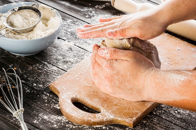 Primo piano della mano del panettiere impastare la pasta di pane