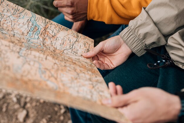 Primo piano della mano dell'escursionista maschio che tiene la mappa