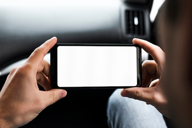 Primo piano della mano dell&#39;uomo che guarda il suo display dello schermo bianco cellulare