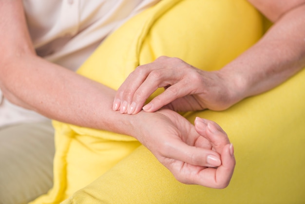 Primo piano della mano della donna che controlla l&#39;impulso del polso