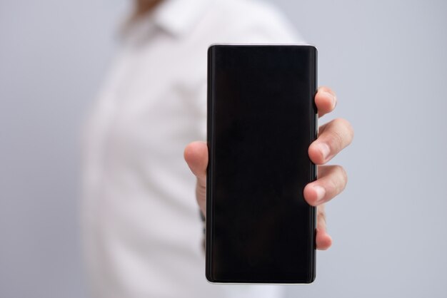 Primo piano della mano maschio che mostra nuovo modello di smartphone