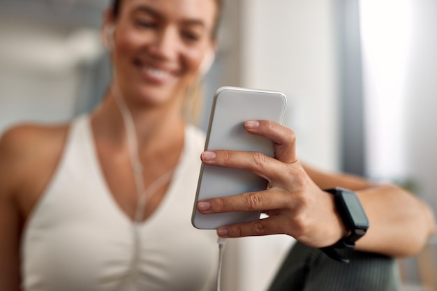 Primo piano della messaggistica di testo dell'atleta femminile sul telefono cellulare