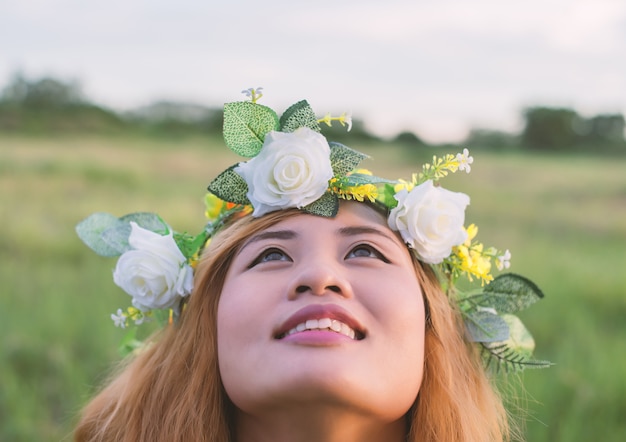 Primo piano della ragazza sorridente con la corona alzando lo sguardo