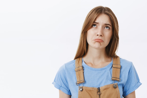 Primo piano della ragazza triste e cupa, sconvolta, alzando lo sguardo e lamentandosi