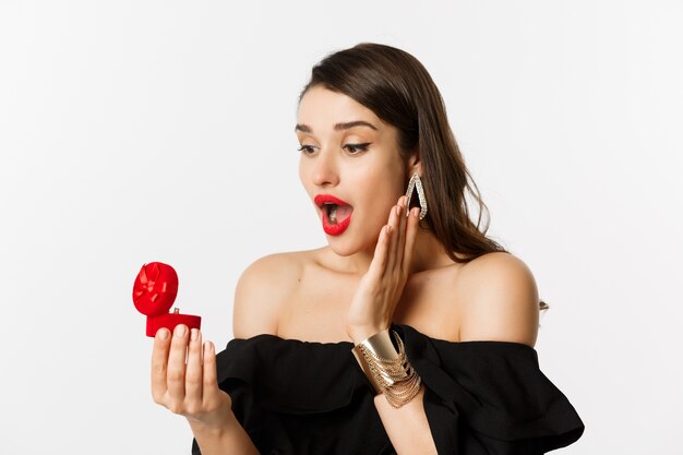 Primo piano della scatola aperta della donna sorpresa con l'anello di fidanzamento, guardando stupito, ricevendo la proposta di matrimonio, fidanzata che si sposa.