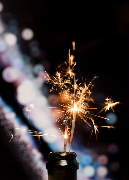 Primo piano della stella filante bruciante in bottiglia sul fondo del bokeh