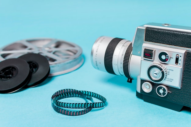 Primo piano della videocamera con bobine di film e pellicole su sfondo blu