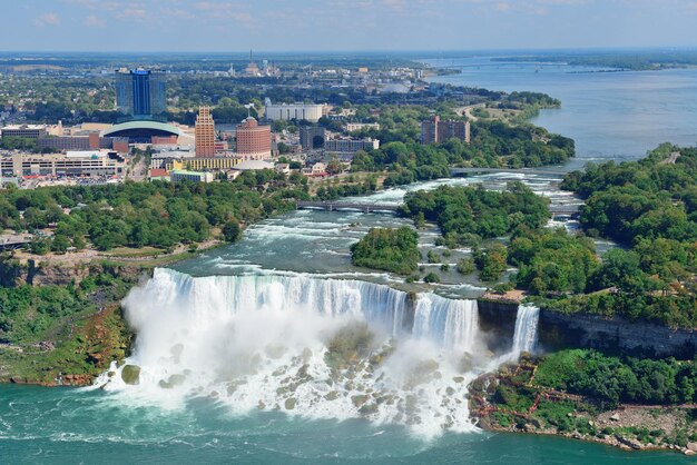 Primo piano delle cascate del Niagara nel giorno sopra il fiume con gli edifici