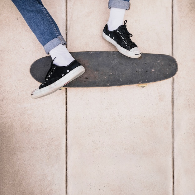 Primo piano delle gambe dello skateboarder su skateboard