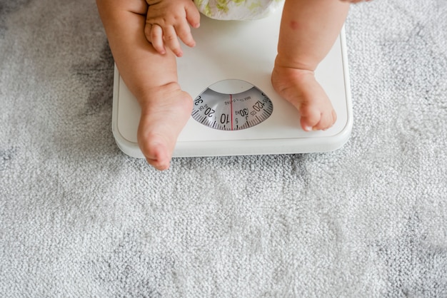 Primo piano delle gambe di un bambino su una bilancia