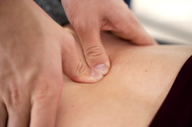 Primo piano delle mani che massaggiano il paziente