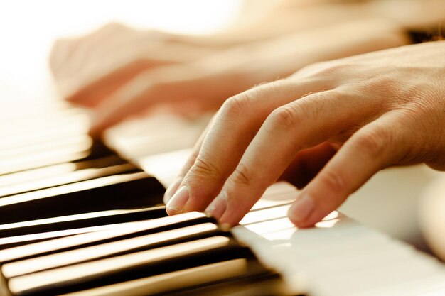 Primo piano delle mani che suonano musica per pianoforte e concetto di hobby