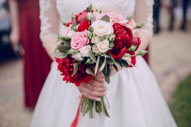 Primo piano delle mani che tengono il bouquet di nozze