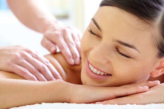 Primo piano delle mani del massaggiatore massaggio schiena di un cliente