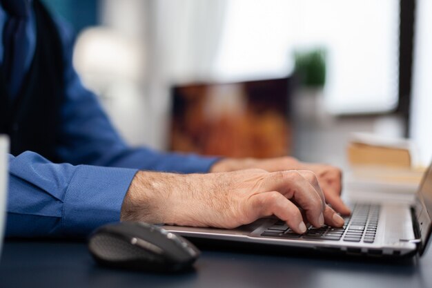 Primo piano delle mani dell'uomo anziano che digitano