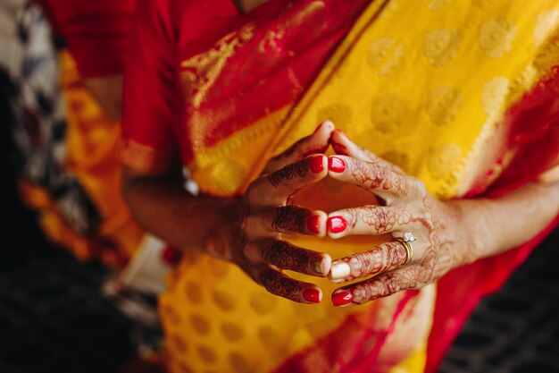 Primo piano delle mani della sposa indù coperto con tatuaggi all&#39;hennè