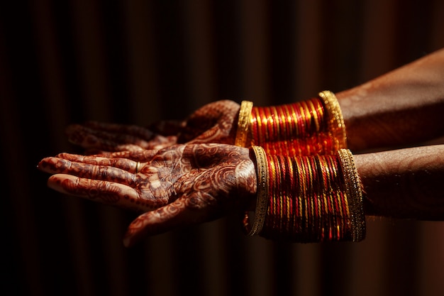 Primo piano delle mani della sposa indù coperto con tatuaggi all&#39;hennè