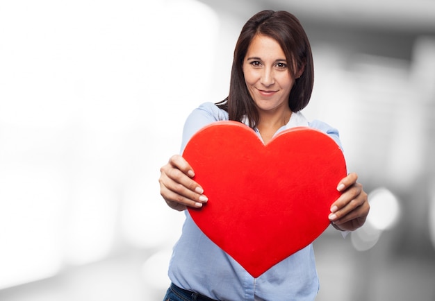 Primo piano delle mani di affari che tiene un cuore rosso